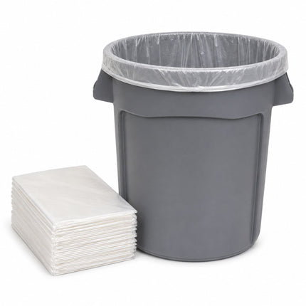 A gray plastic trash can with a clear plastic liner inside, shown next to a stack of clear plastic bag liners on a white background.