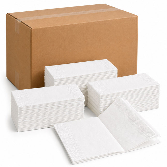 A large brown cardboard shipping box behind several stacks of white paper napkins, with one open napkin displayed in front, on a clean white background.