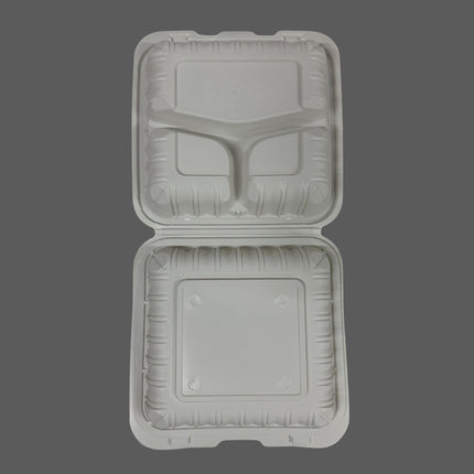 An open square compartment food tray made of molded foam or plastic, shown from above on a plain dark gray background.